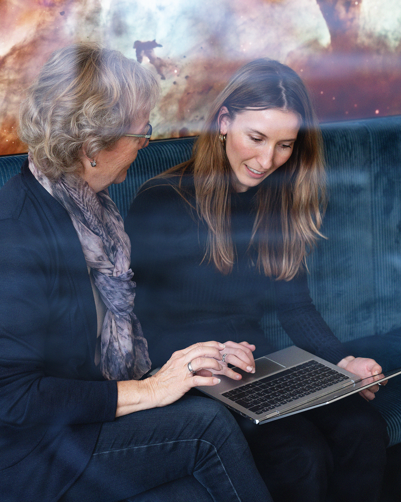 Two women with notebook sitting in a meeting room and talking